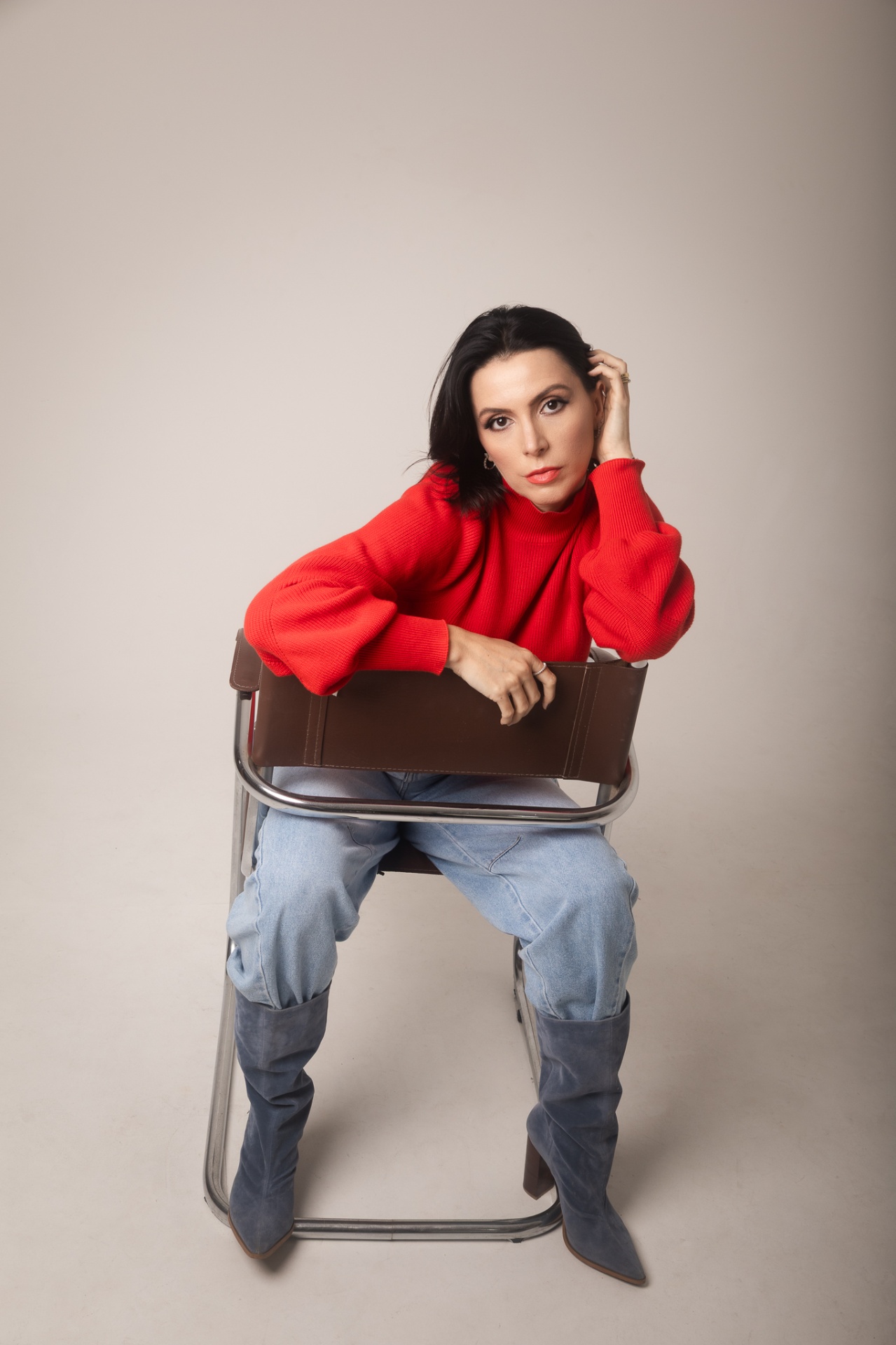 Look editorial AK — tricô vermelho com jeans claro e bota azul